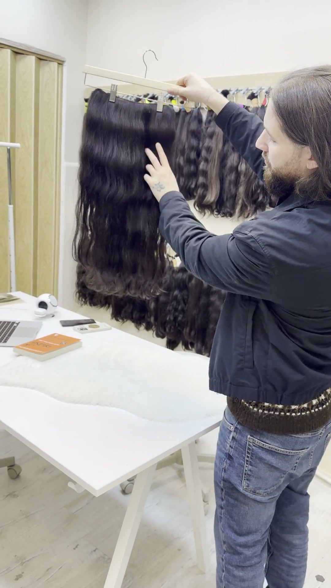 Hair specialist inspecting a dark wavy extension weft.